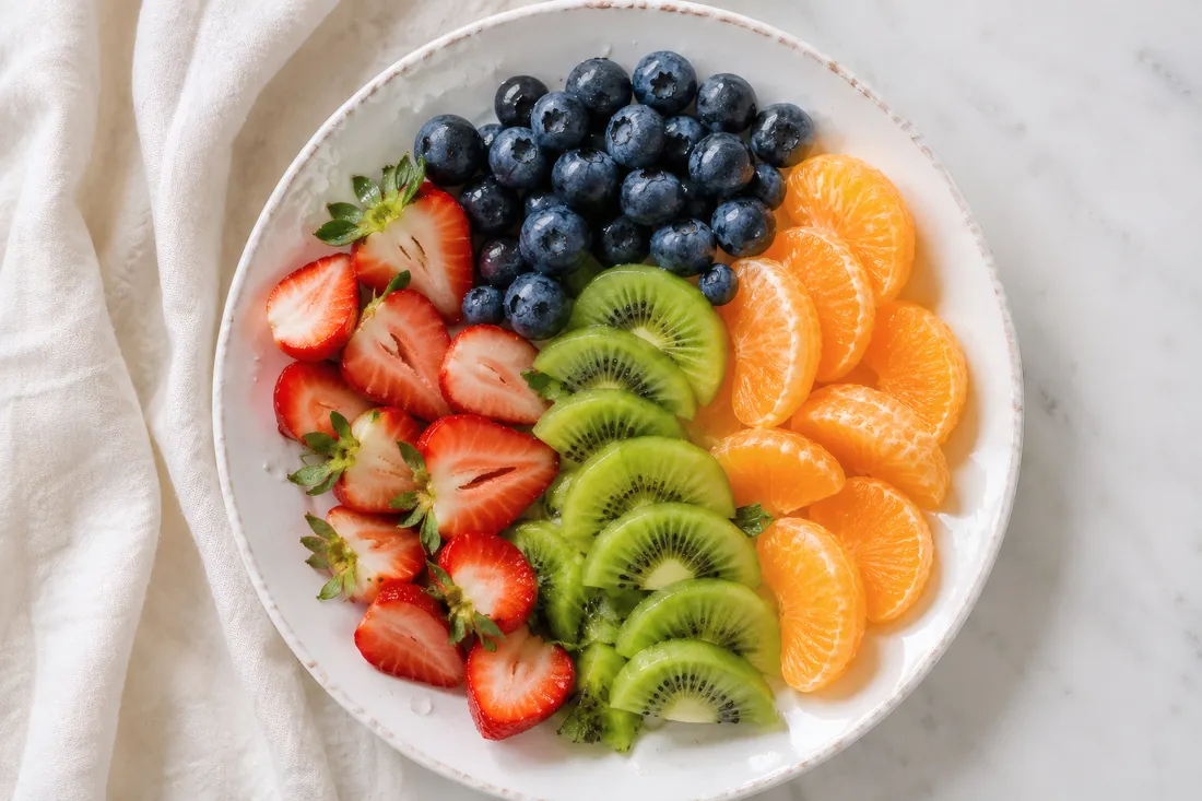 Fresh fruit platter flat lay with strawberries, blueberries, and kiwi